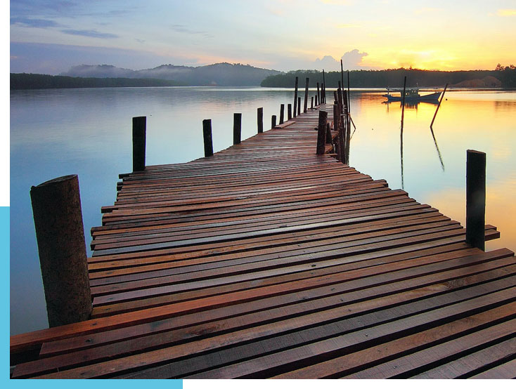 Holzsteg an einem schönen See im Hintergrund Sonnenuntergang