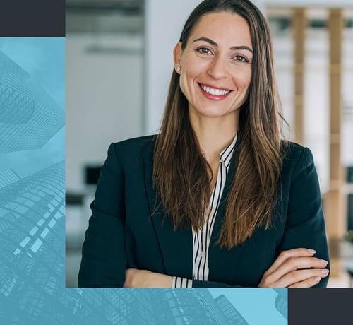 Eine Businessfrau in einem Blazer mit verschränkten Armen in einer modernen Büroumgebung