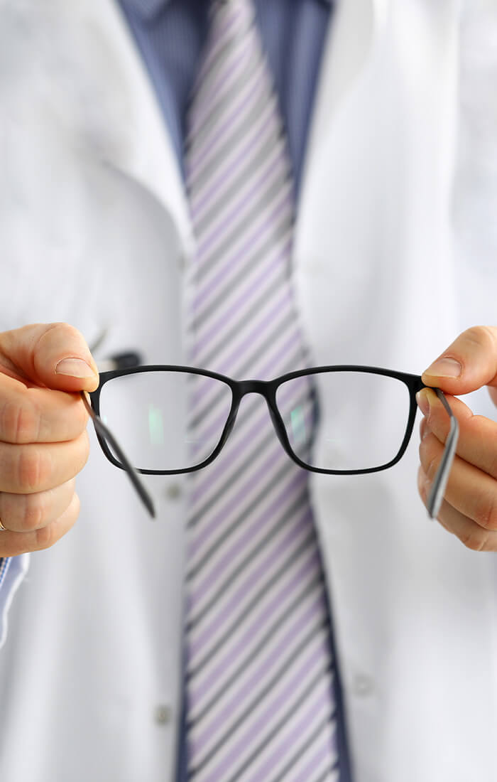 Ein Optiker hält eine Brille in der Hand