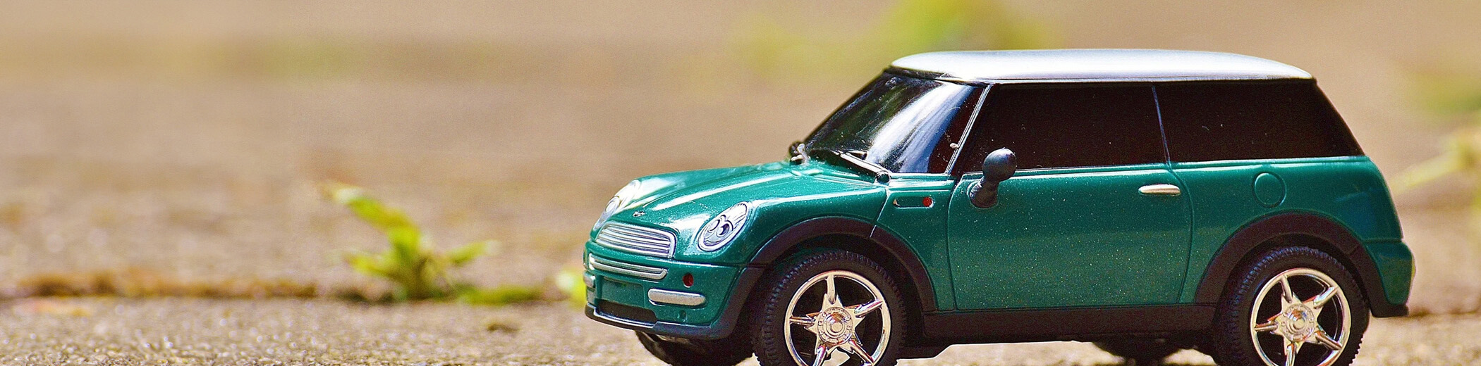 kleines Spielzeug-Modell eines Mini steht auf dem Asphalt